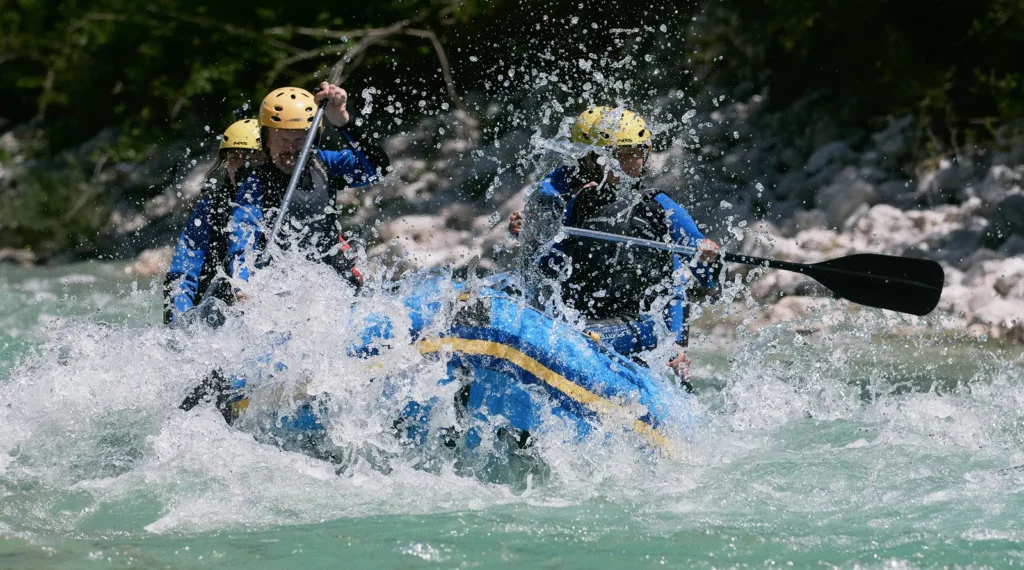 Dolgi rafting čez močne brzice Soče pri Bovcu, raft v oblaku pršca