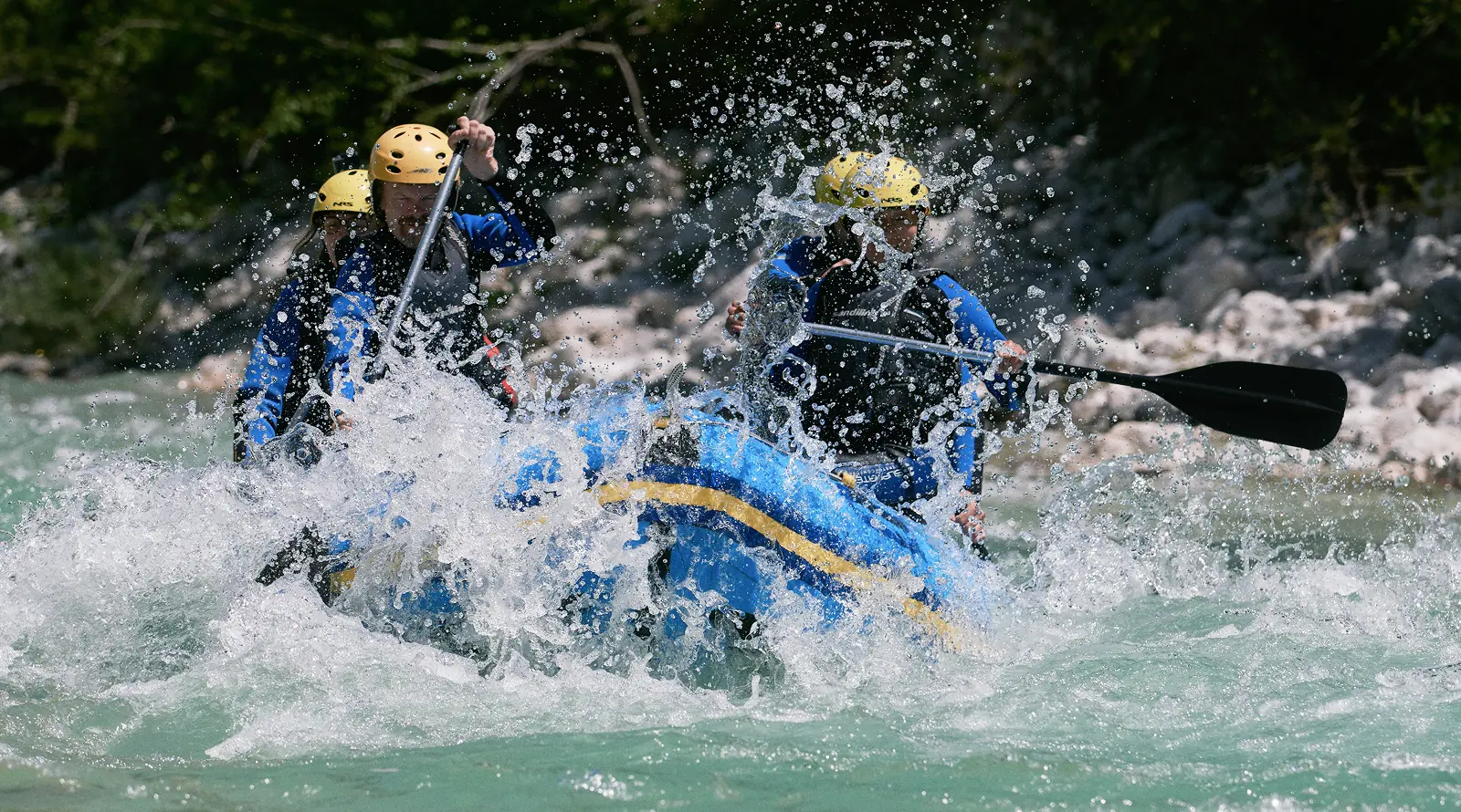 Dolgi rafting čez močne brzice Soče pri Bovcu, raft v oblaku pršca