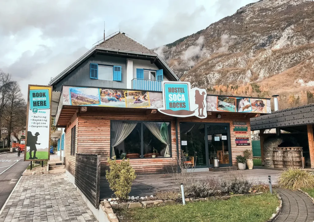 Lesena stavba Hostla Soča Rocks pod gorskim pobočjem v Bovcu.