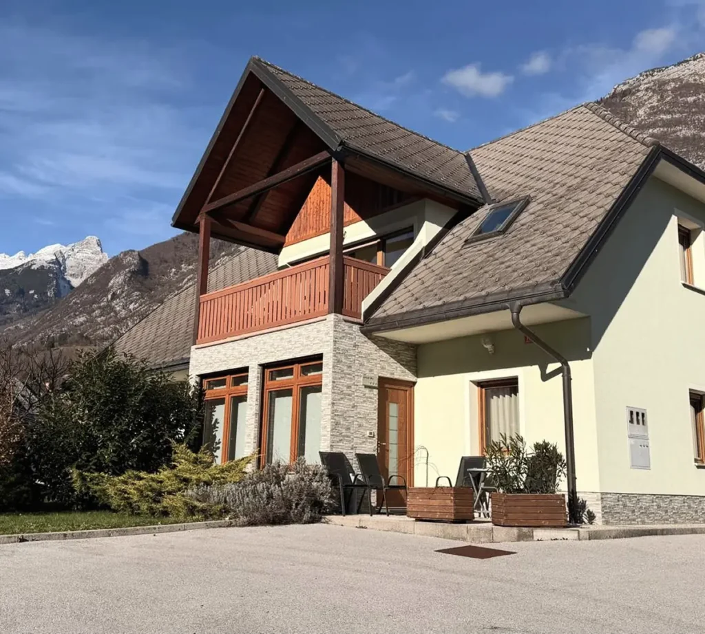 Hiša z balkonom in pogledom na gore v Bovcu, kjer je Apartma Isonzo ob Hostlu Soča Rocks.