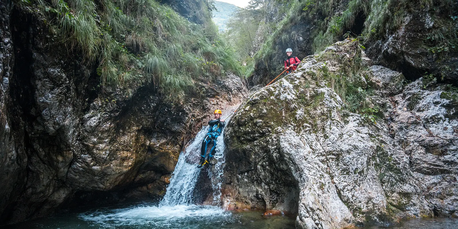 Spust po slapu v kanjonu Sušec pri Bovcu, najtoplejši in družini prijazen kanjon.