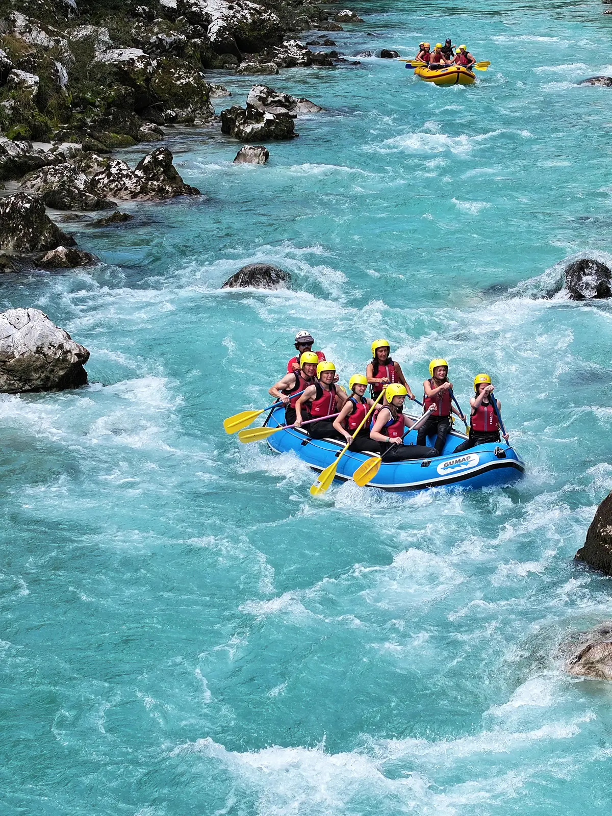 Skupina na raftingu po smaragdnih brzicah Soče pri Bovcu z Aktivni Planet