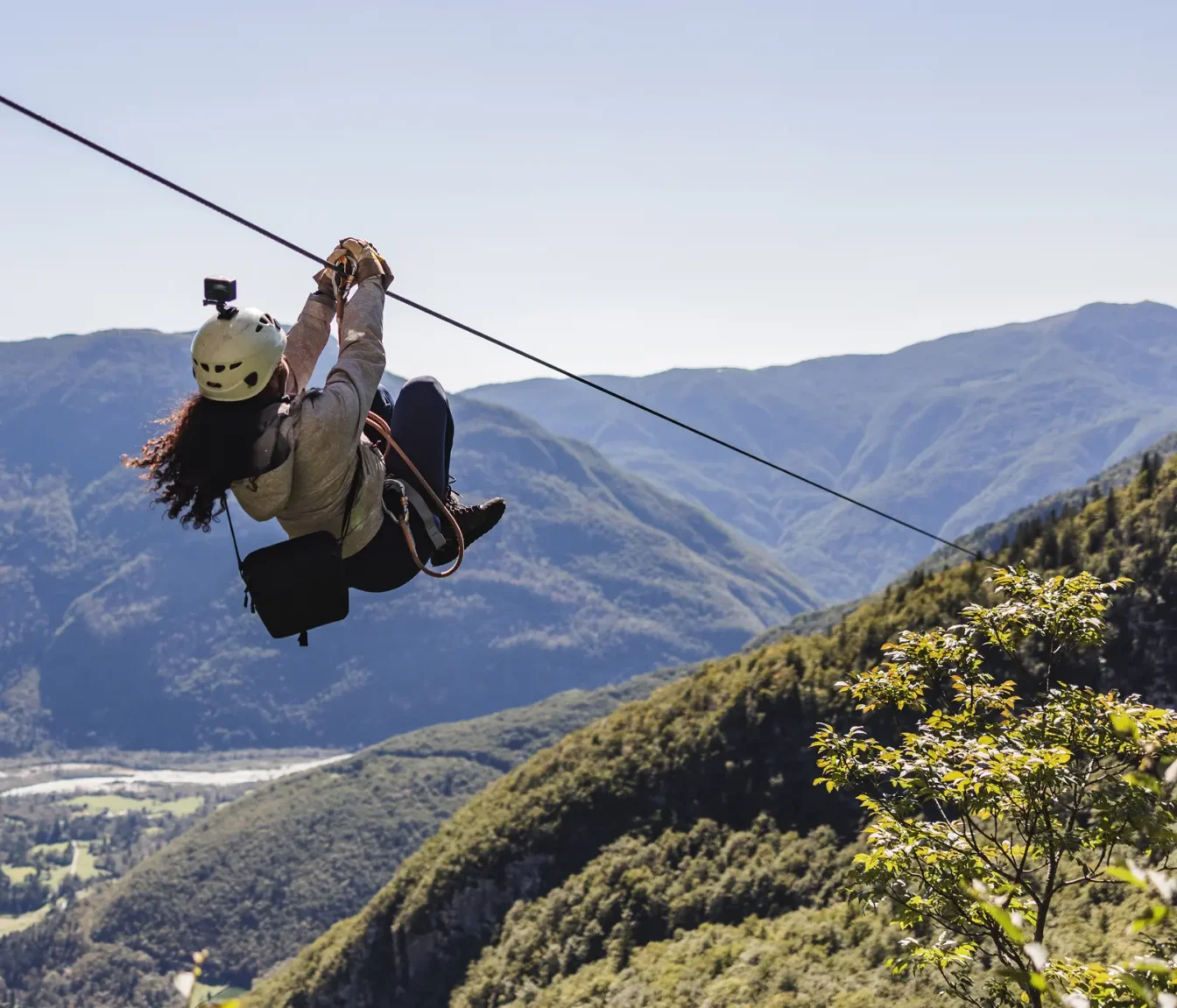 Obiskovalka se odrine s platforme na zipline jeklenici, vodnik Aktivnega planeta jo spremlja s platforme.